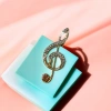 A fashionable and exquisite accessory with a gold diamond-encrusted treble clef music theme details Picture